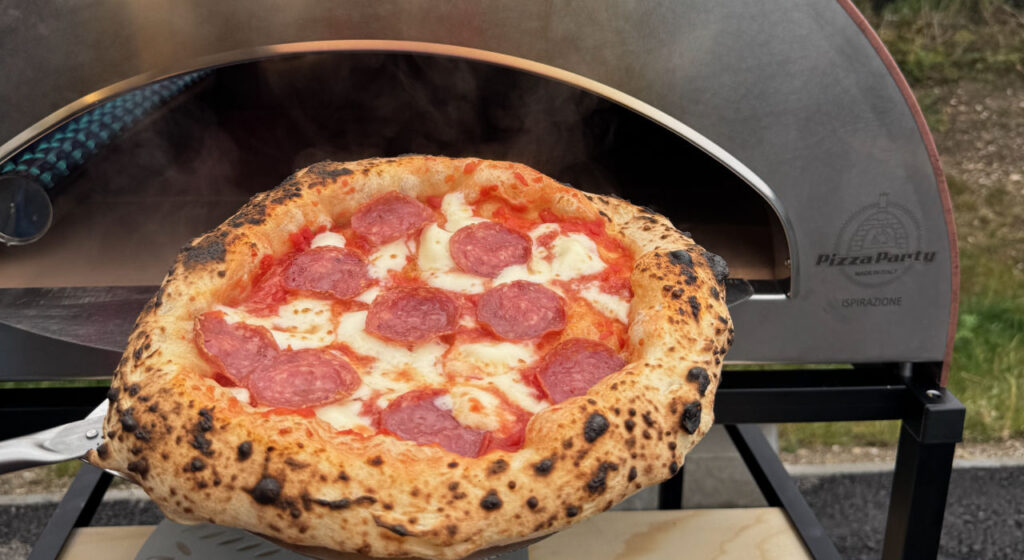 Frisch gebackene neapolitanische Pizza wird aus dem Pizzaofen geholt