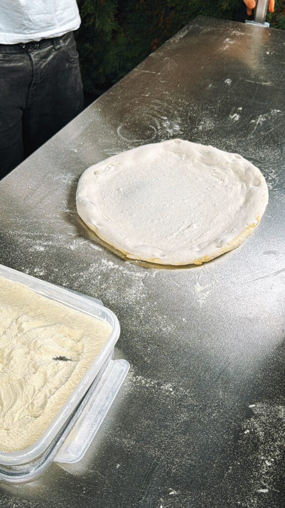 Teigling auf der Edelstahlplatte – erst als Ballen, dann ausgebreitet