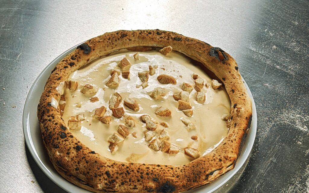 Tiramisu Pizza mit grob zerbrochene Biskotten auf der Mascarponecreme