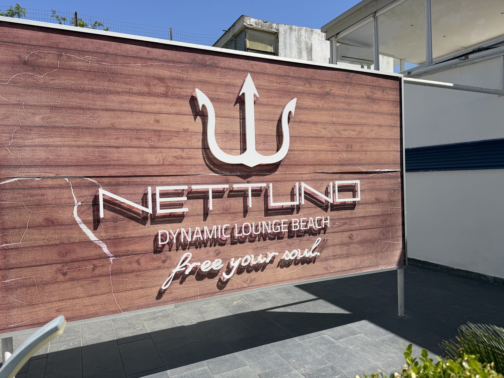 Eingangsschild des Lido Nettuno bei Boscoreale mit Blick auf den schwarzen Sandstrand