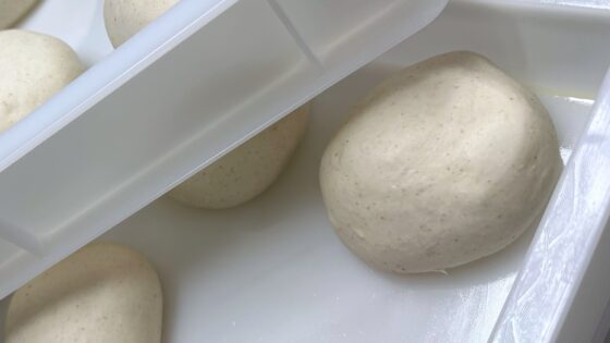 Nahaufnahme eines Pizzateigballens mit feinen braunen Punkten durch Keimanteil im Tipo-0-Mehl