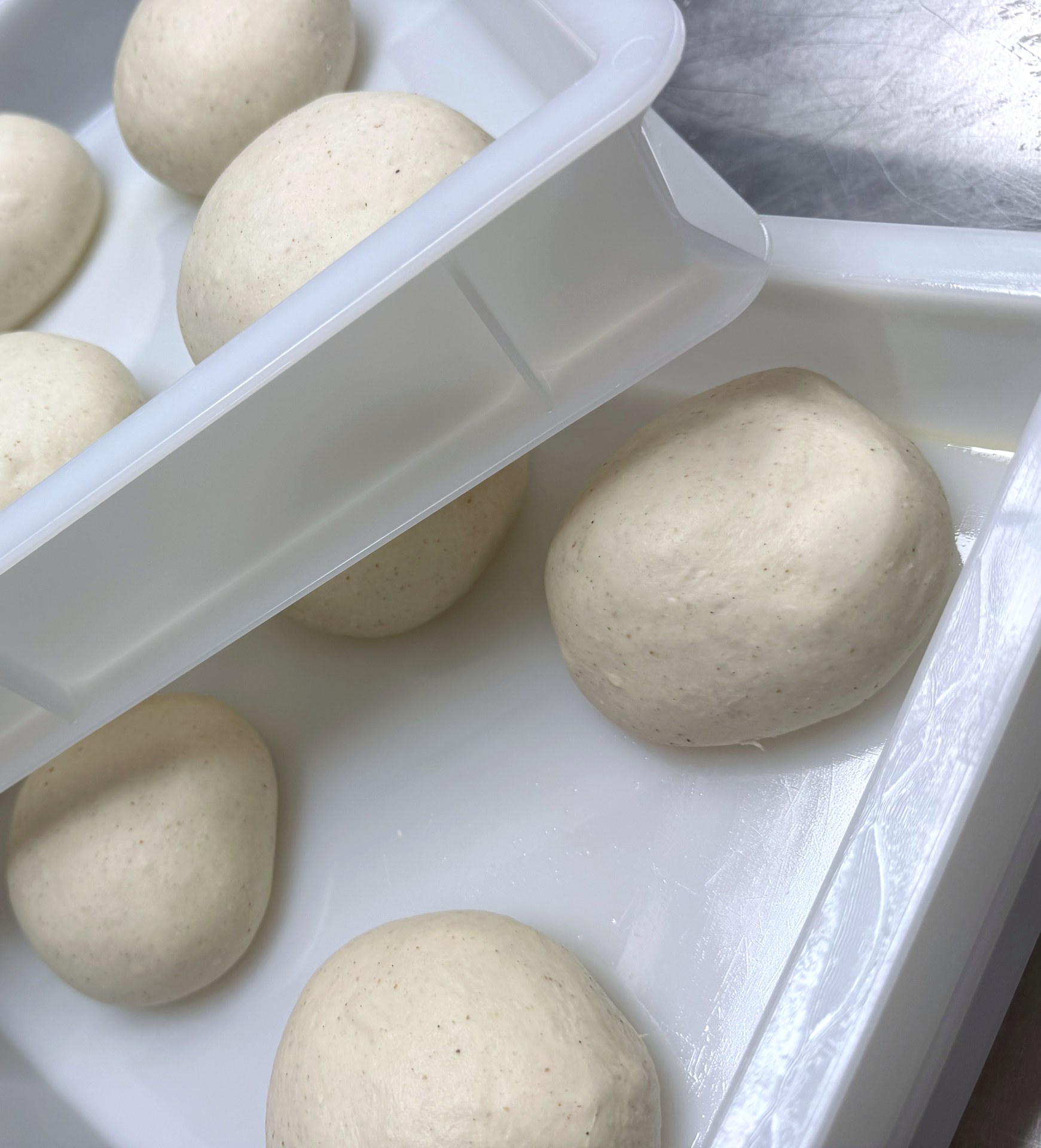 Nahaufnahme eines Pizzateigballens mit feinen braunen Punkten durch Keimanteil im Tipo-0-Mehl