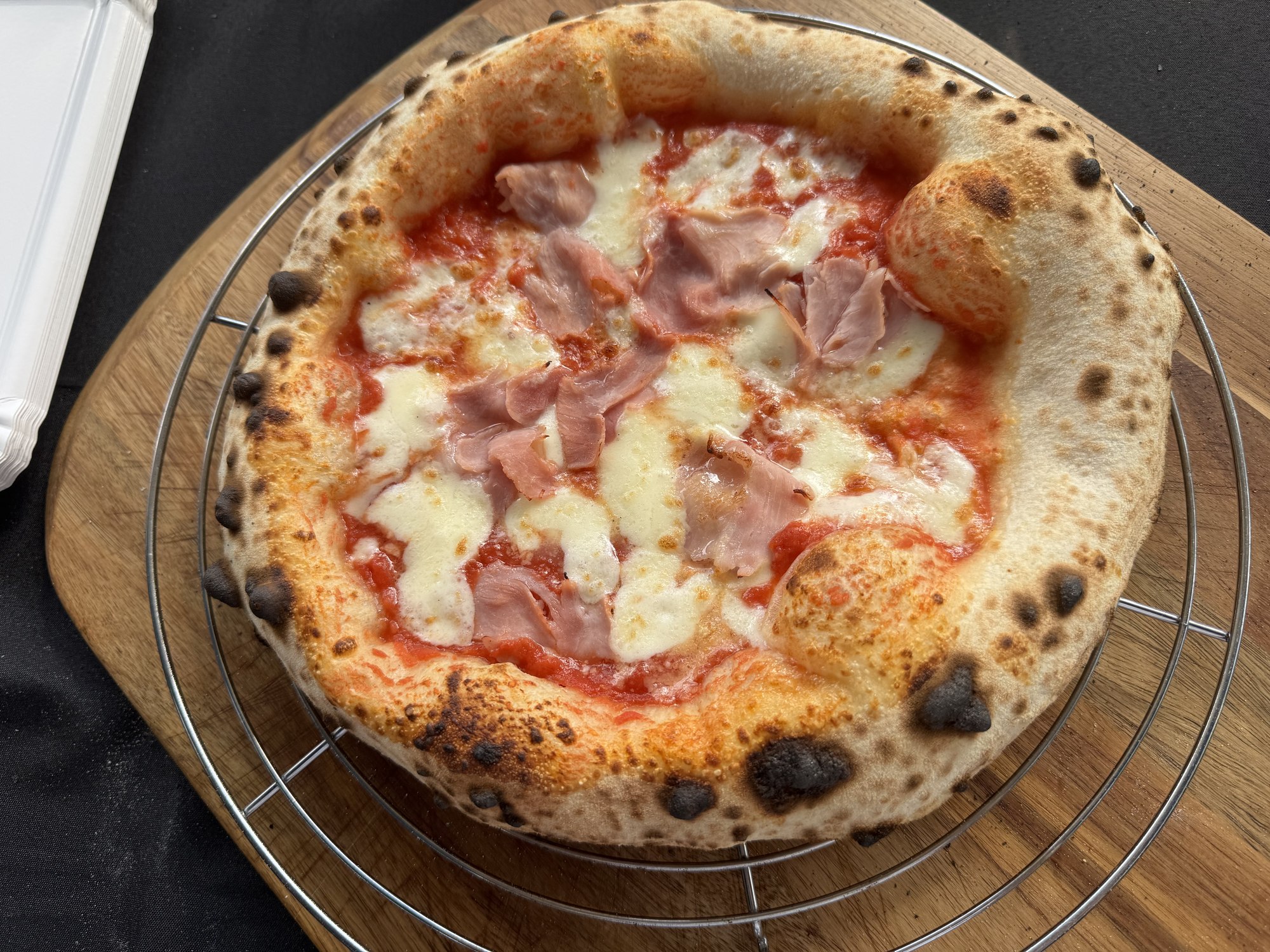 Neapolitanische Pizza mit Schinken auf einem Rost