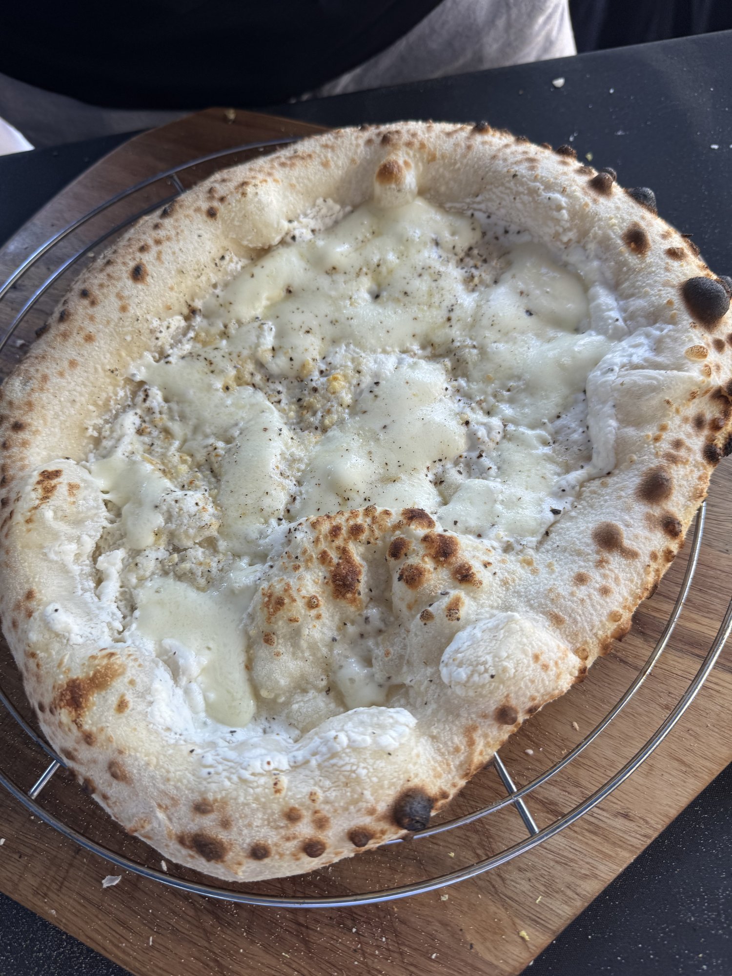Gebackene Pizza mit weißer Ricotta-Sauce als Base, Fior di Latte und frisch gemahlenem Pfeffer
