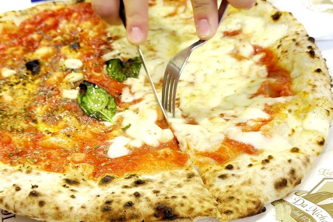 Ruota di Carro Pizza bei L'Antica Pizzeria Da Michele in Neapel, wird mit Messer und Gabel geschnitten