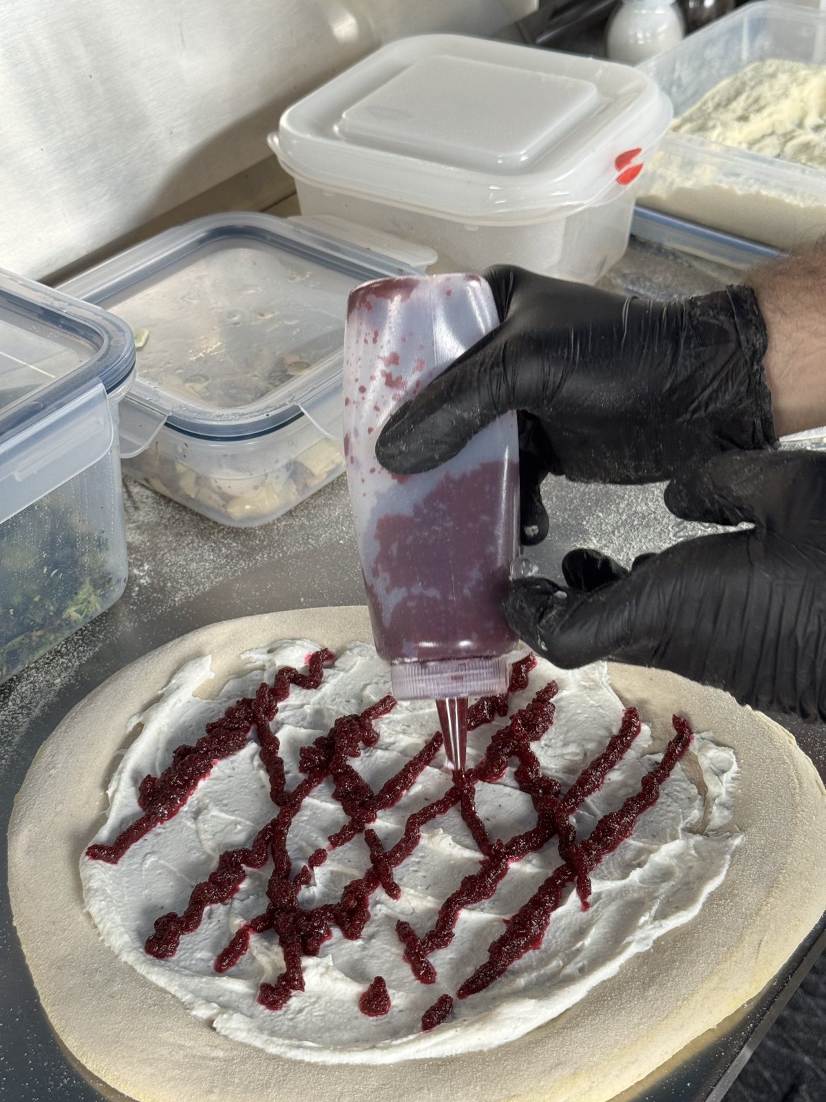 Rote-Rüben-Creme als Gitter auf der Pizza, aufgetragen mit der Quetschflasche