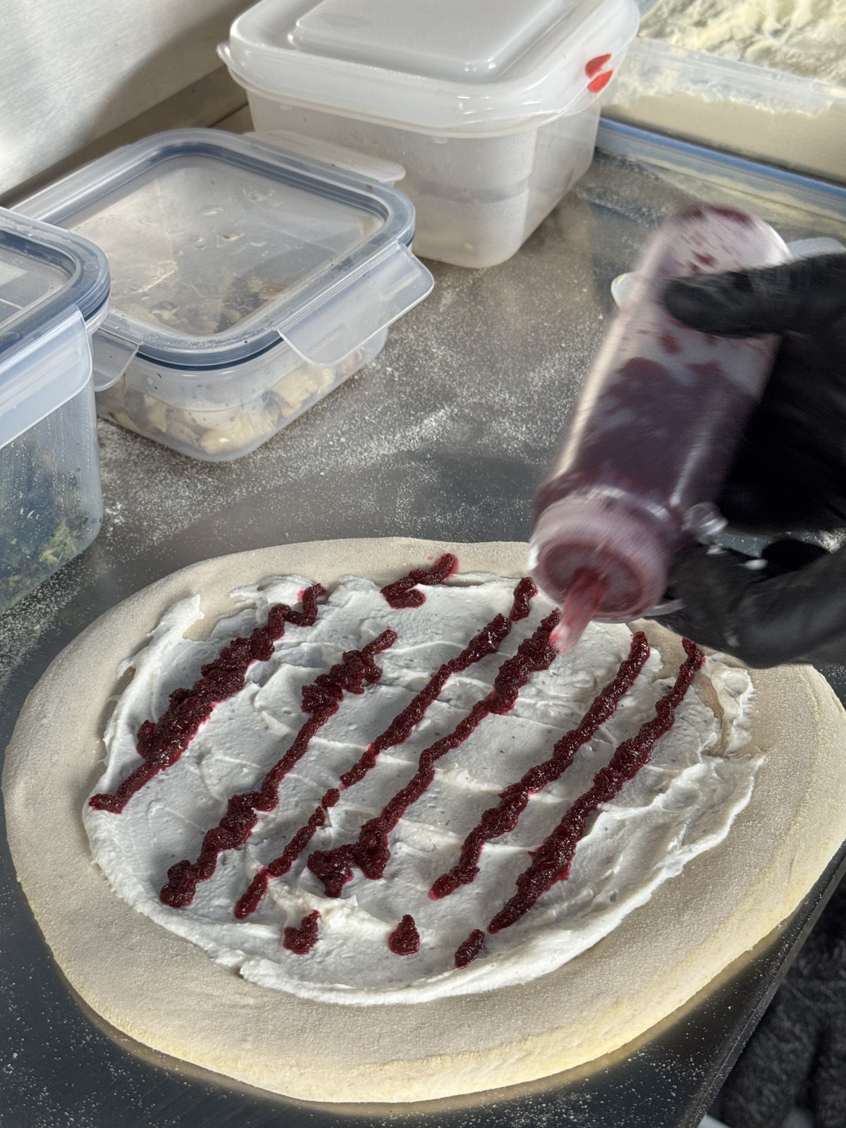 Rote-Rüben-Creme wird mit der Quetschflasche in Streifen auf die weiße Ricotta-Sauce gezogen
