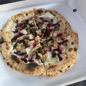 Fertige vegetarische Pizza mit Roten Rüben, Artischocken und Brokkoli im Pizzakarton